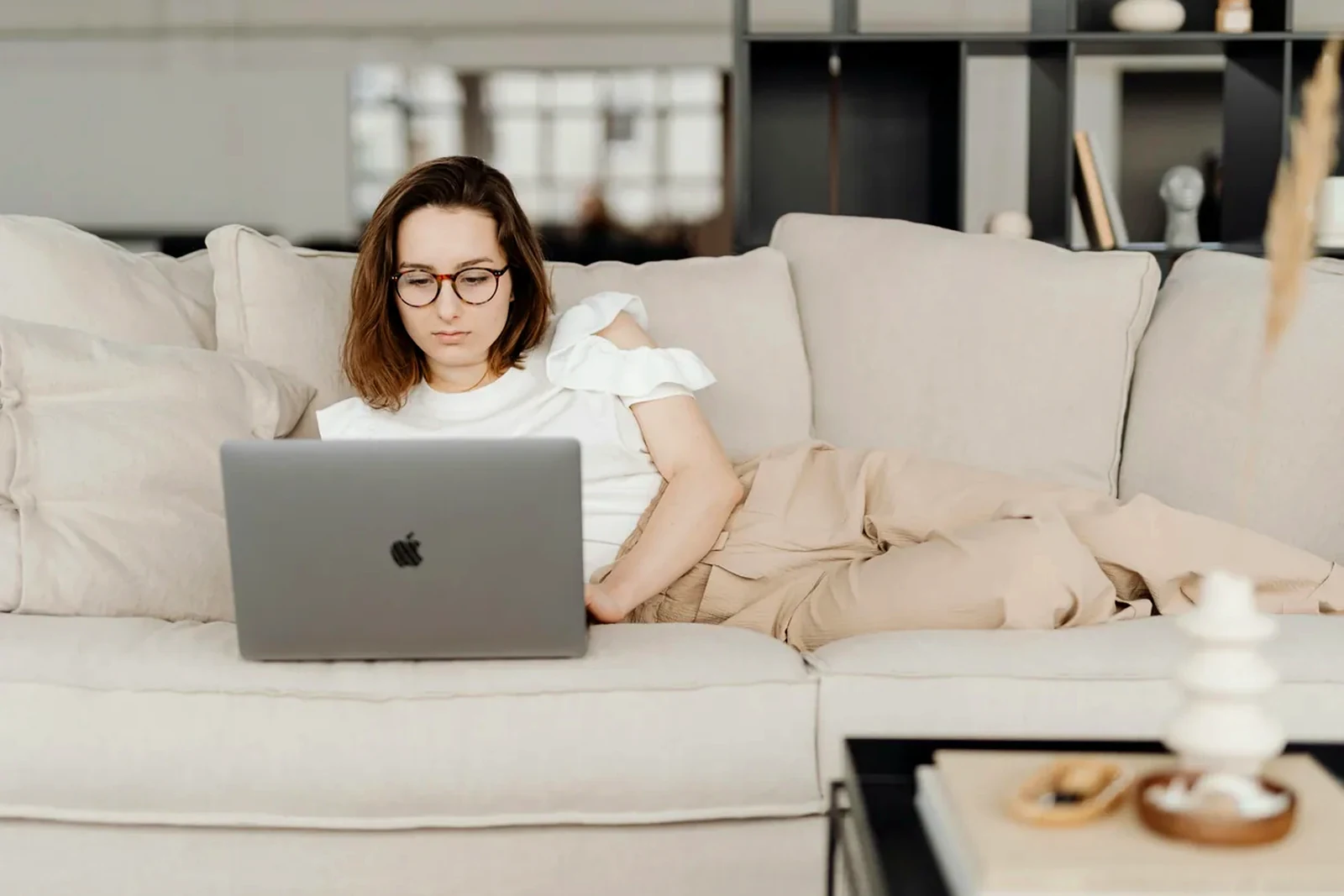 Freelancer working from a calm sofa setup with a laptop in a premium home interior.